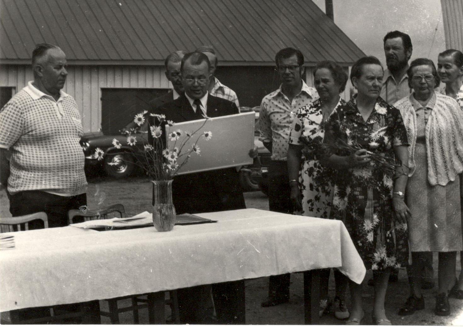 Eino, Mikko, Sulo, Elna, Martta Lauri ja Vieno Eino, Mikko, Sulo, Elna, Martta, Lauri ja Vieno Lauronen sekä Tyyne Parviainen. Mikko Laurosen takaa kurkistavat Onni ja Mauri Lauronen Kinnasniemessä sukuseuran perustamisjuhlassa 1975